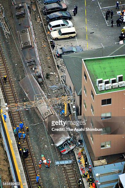 In this aerial image, police officers investigate the accident site that Sanyo Electric Railway Co. Train and a truck collided near Arai Station on...