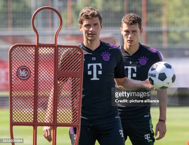 August 2023, Bavaria, Munich: FC Bayern Munich's Benjamin Havard and Thomas Müller take part in their team's public training session at the club's...