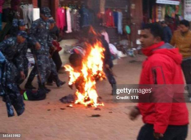 An exiled Tibetan monk sets himself on fire at Boudhanath Stupa in Kathmandu on February 13, 2013. A Tibetan monk doused himself in petrol in a...