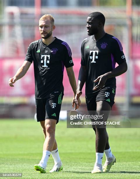 Bayern Munich's Austrian midfielder Konrad Laimer and Bayern Munich's French defender Dayot Upamecano talk during a public training session at the...