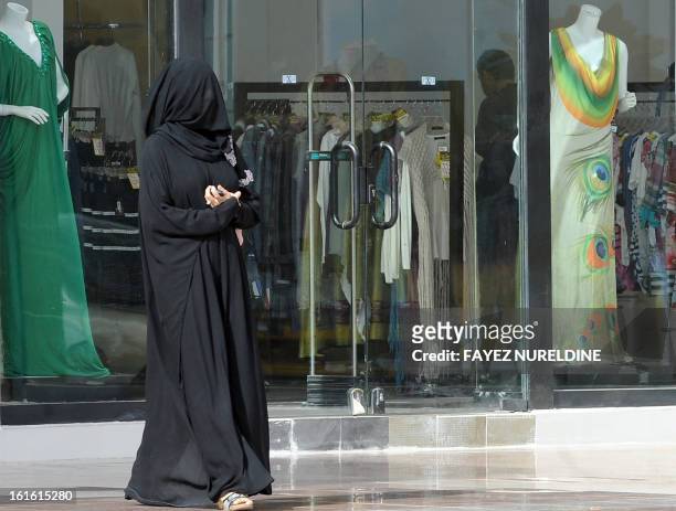 Picture taken on February 4, 2013 shows a Saudi woman walking past a clothes store at a shopping mall, in the Saudi capital of Riyadh. AFP...