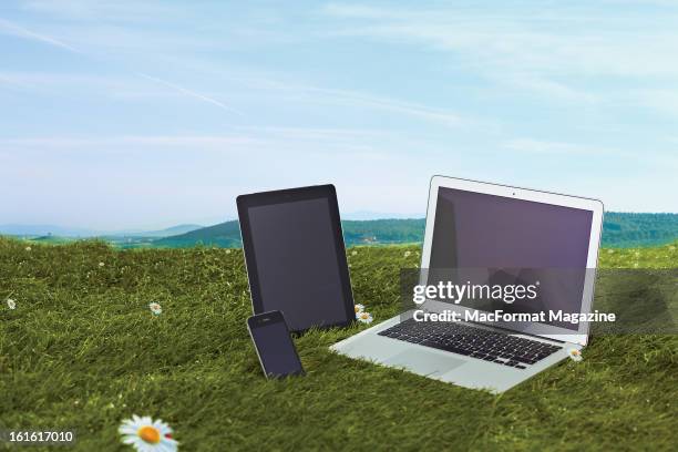 Selection of Apple products, including iPhone, iPad and MacBook Air, on a lawn during a summer day, taken on June 18, 2012.