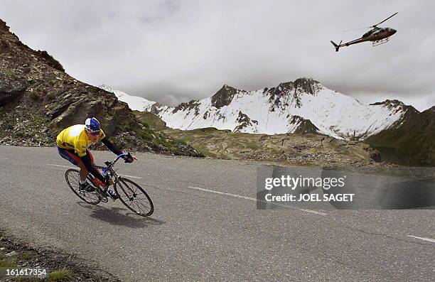 The yellow jersey US Lance Armstrong takes a curb in a downhill past an helicopter during the15th stage of the 87th Tour de France between Briancon...