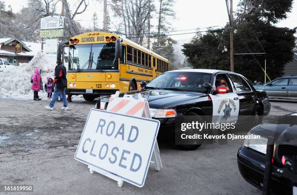 Children board a school bus a day after a standoff between law enforcement officers and who is believed to be suspected murderer and former Los...