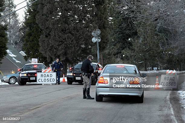 California Highway patrol officers stop a car at a road block a day after a standoff between law enforcement officers and who is believed to be...