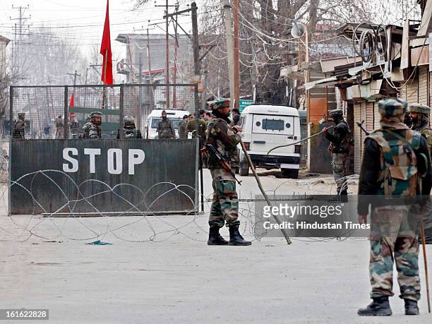 Army soldiers stands near a barricade on February 13, 2013 in Sopore some 50 Km from Srinagar, India. Curfew was was imposed by the authorities last...