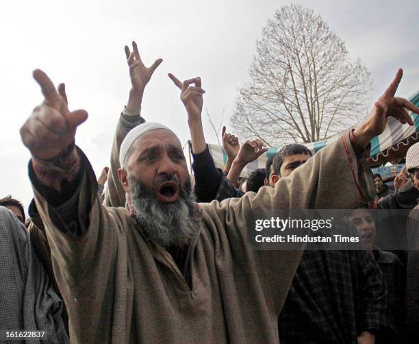 People shout slogans outside the house of Afzal Guru after curfew was lifted in some areas on February 13, 2013 in Sopore some 50 Km from Srinagar,...
