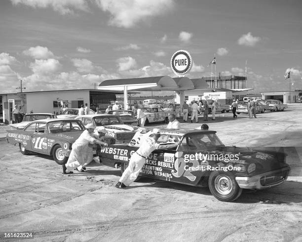 July 4, 1960: Crewmembers push the 1959 Ford Thunderbird of Gerald Duke to pit road after getting fuel in the garage area of Daytona International...