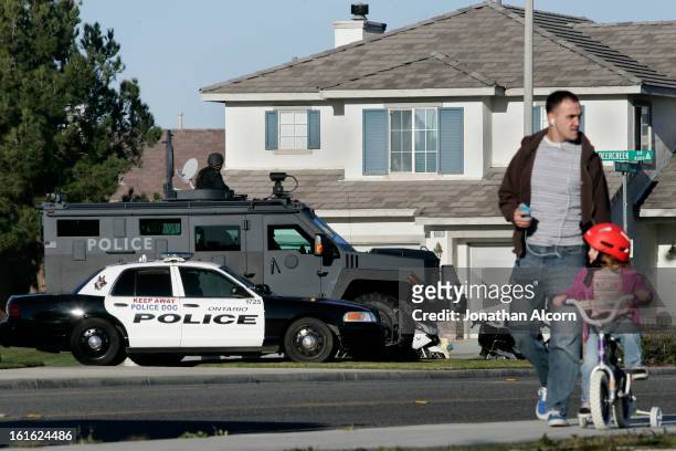 Man and his daughter pass near a heavy police presence for the funeral of Riverside police Officer Michael Crain arrives at Grove Community Church in...