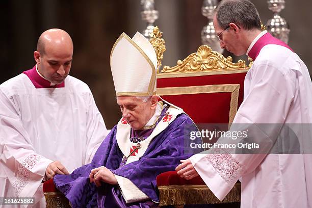 Pope Benedict XVI is helped as he leads the Ash Wednesday service at the St. Peter's Basilica on February 13, 2013 in Vatican City, Vatican. Ash...