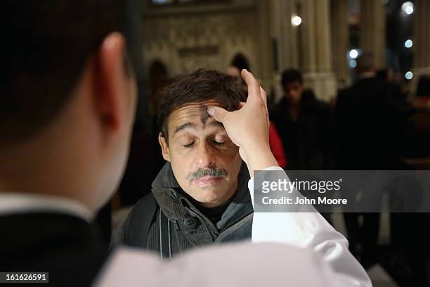 Man receives a cross of black ashes on his forehead on Ash Wednesday at St. Patrick's Cathedral on February 13, 2013 in New York City. Ash Wednesday...