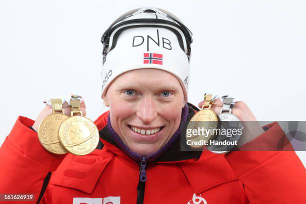 In this handout image provided by IBU, Tora Berger of Norway poses holding her medals including her gold medal after taking first place in the IBU...