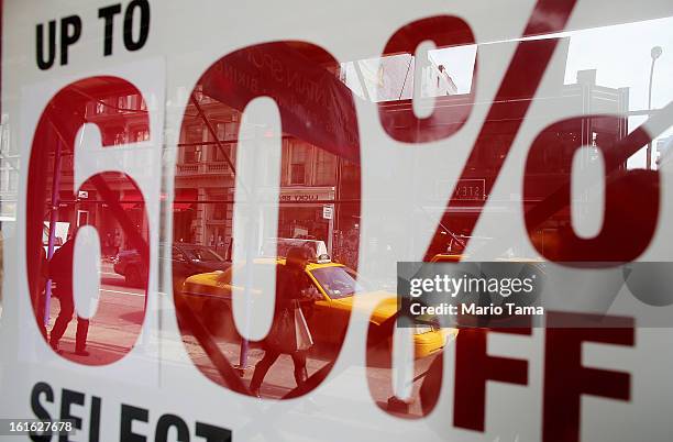Woman carrying a shopping bag on Broadway in Manhattan is reflected in a window with a sale sign on February 13, 2013 in New York City. The Commerce...