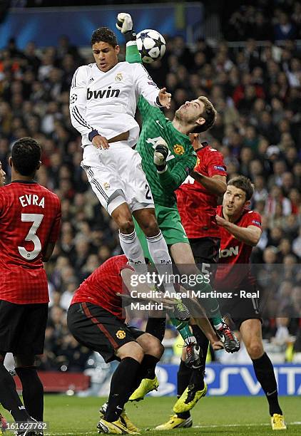 Goalkeeper David de Gea of Manchester United competes for a high ball with Raphael Varane of Real Madrid during the UEFA Champions League Round of 16...