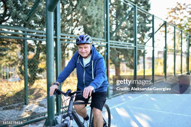 smiling senior male enjoying bicycle ride outside - track cycling stock pictures, royalty-free photos & images