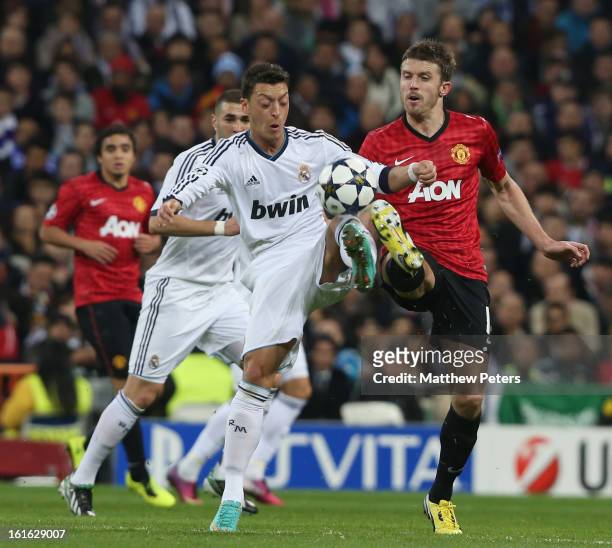 Michael Carrick of Manchester United in action with Mesut Ozil of Real Madrid during the UEFA Champions League Round of 16 first leg match between...