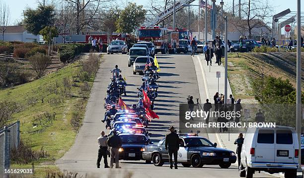 Funeral procession approaches the Grove Community Church in Riverside, California, on February 13, 2013 for the funeral of slain Riverside policeman...