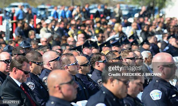 Police officers, friends and family attend a memorial service for slain Riverside police officer Michael Crain at the Grove Community Church in...