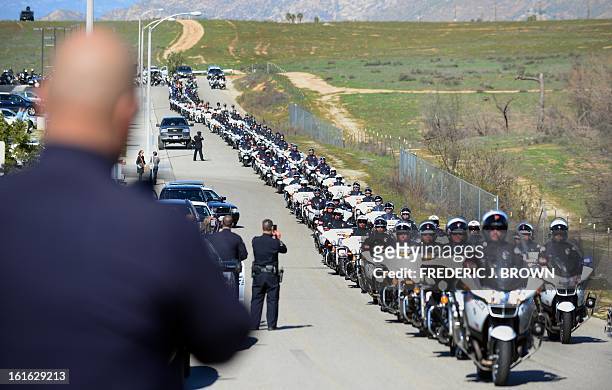 Convoy of police vehicles make their way out following a memorial service for slain Riverside police officer Michael Crain at the Grove Community...