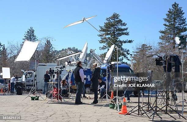 Journalists wait near a roadblock of Highway 38 at Angelus Oaks, California, on February 13, 2013. A former US cop wanted for at least three murders...