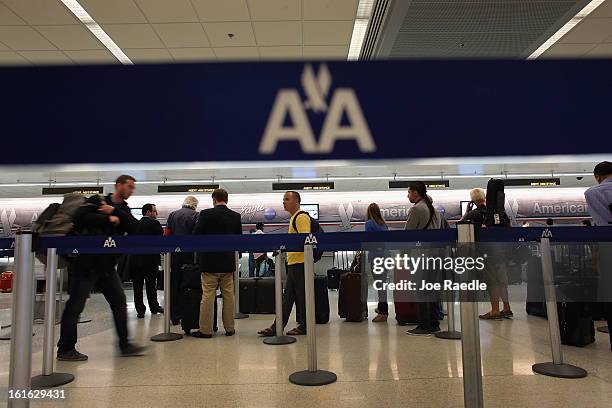People wait in line at the American Airlines ticket counter in the Miami International Airport on February 12, 2013 in Miami, Florida. Reports...