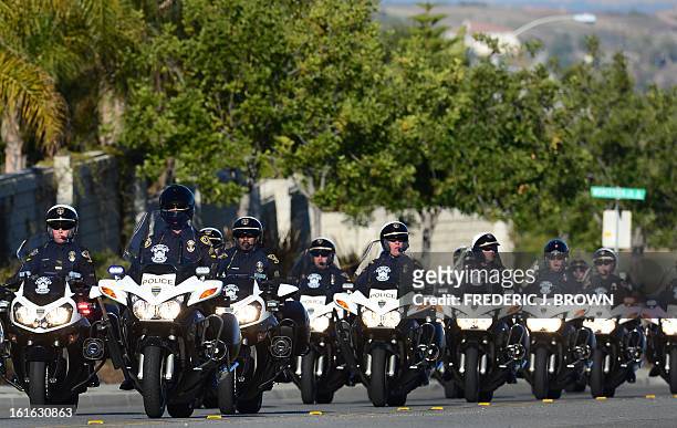 Convoy of motorcycle police ride toward the Grove Community Church for a memorial service for slain Riverside police office Michael Crain in...