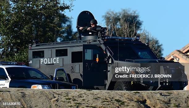 Armed police personnel keep watch around the Grove Community Church where a memorial service was underway for slain Riverside police office Michael...