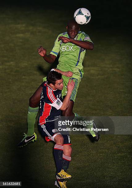 Djimi Traore of the Seattle Sounders goes up for a header over Diego Fagundez of the New England Revolution during the first half of the FC Tucson...