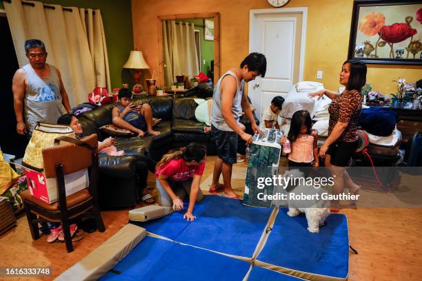 Kahului, Maui, Thursday, August 17, 2023 - Relyn Delfin, right, oversees the laying of mattresses and blankets in preparation for a night's sleep....