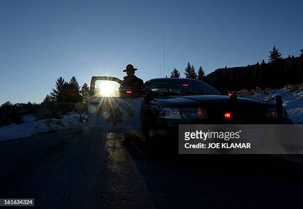 California Highway Patrol officer guards a roadblock in early hours February 13, 2013 on Highway 38 near the Big Bear Lake in the San Bernardino...