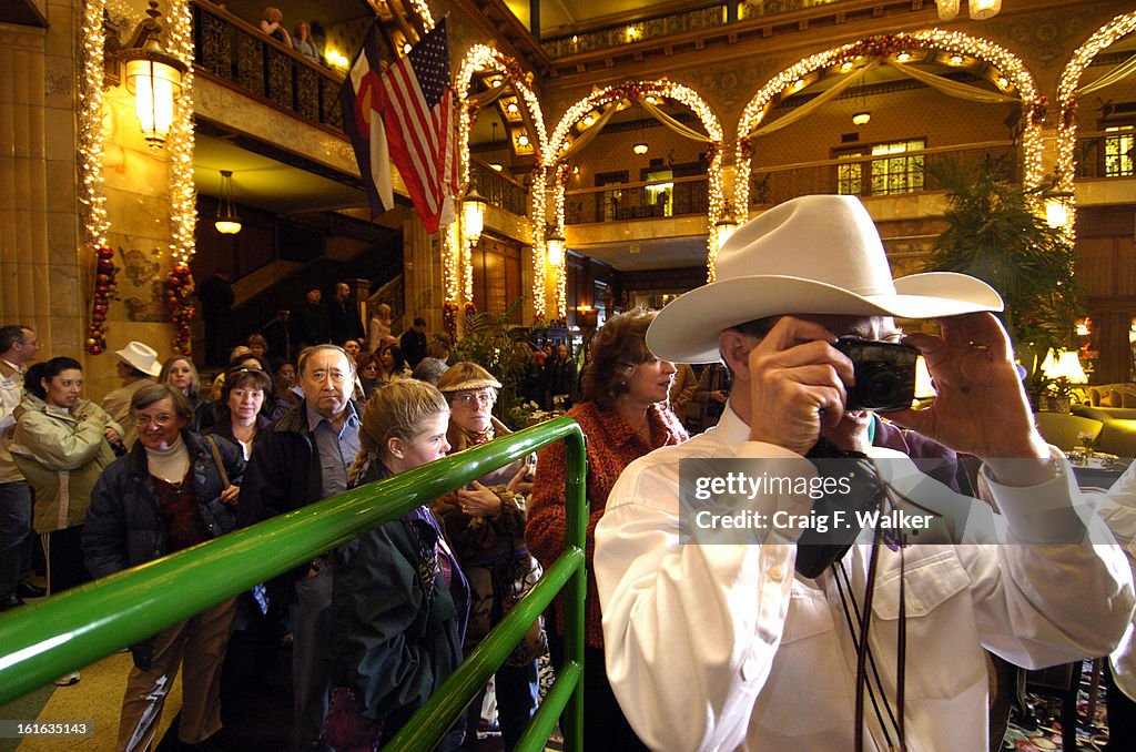 DENVER, CO, JAN. 20, 2006- 011806_NWSS_CFW - Justin Cumming of the National Western Stock Show Junior Auction Committee photographs a visitor with Grand Champion Steer, Husker, and owner Stetson Copus, in downtown Denver, CO. Stetson Copus, 15, of Burkbur