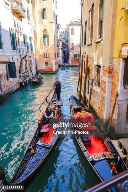 gondola con turisti sul canal grande a venezia - italia - gondola traditional boat foto e immagini stock