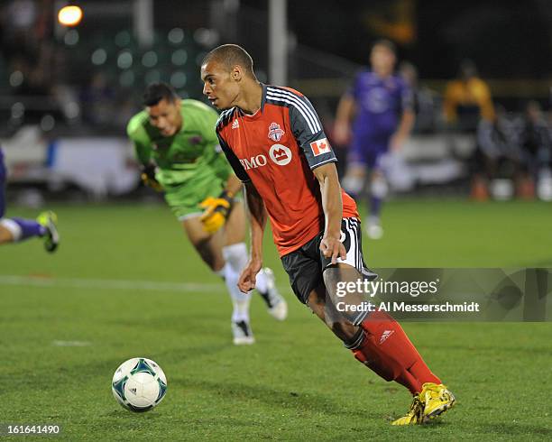 Forward Taylor Morgan of Toronto FC jumps over goalie Miguel Gallardo of Orlando City February 13, 2013 and scores a second period goal in the second...