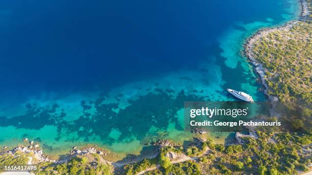 aerial phot of a luxury yacht on a bay with turquoise waters - north aegean greece stock pictures, royalty-free photos & images