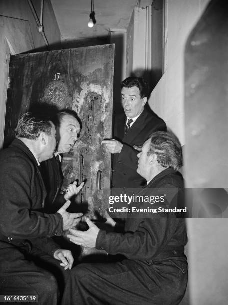 Actors Johnny Rossi, Leo Franklyn , Paddy Hayes and Brian Rix , co-stars of the comedy film 'Nothing Barred', in discussion next to a prison cell...