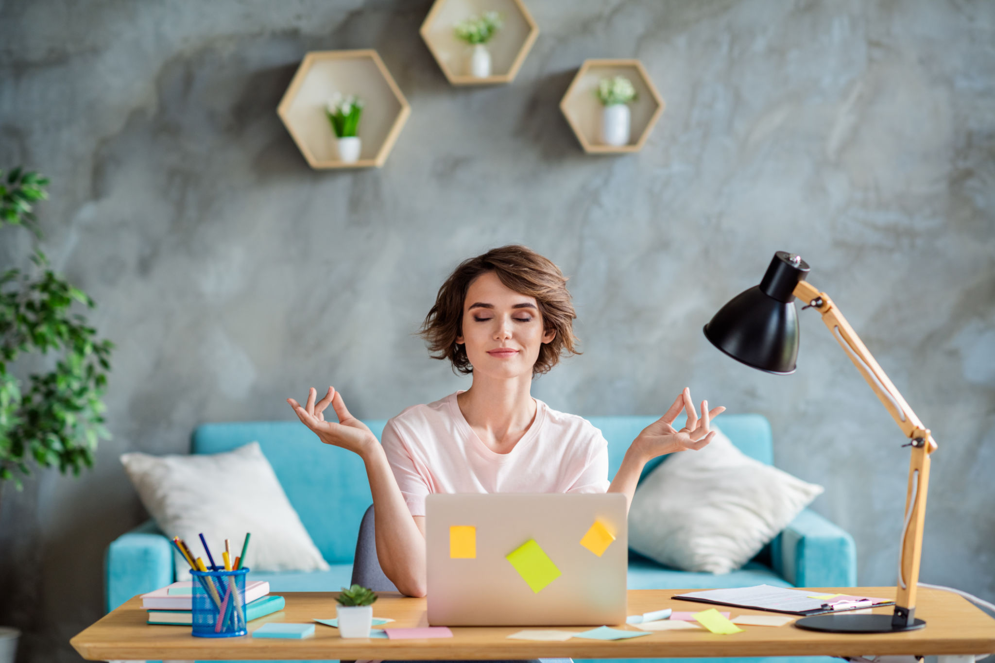 Photo of young attractive woman bob brown hair wearing pink t shirt sitting chair desk balance meditation while working laptop indoors Photo of young attractive woman bob brown hair wearing pink t shirt sitting chair desk balance meditation while working laptop indoors
