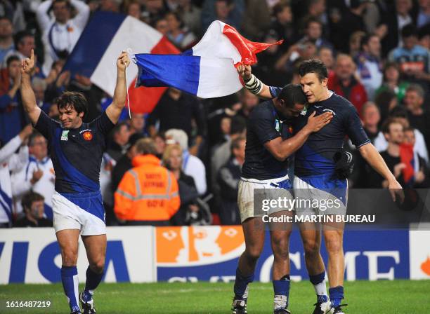 France's winger Christophe Dominici, France's flanker Thierry Dusautoir and France's fullback Damien Traille celebrate at the end of the rugby union...