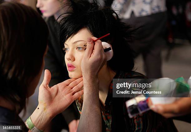 Make-up artist Kabuki preps model Lindsey Wixson backstage at the Jeremy Scott fall 2013 fashion show during MADE Fashion Week at Milk Studios on...