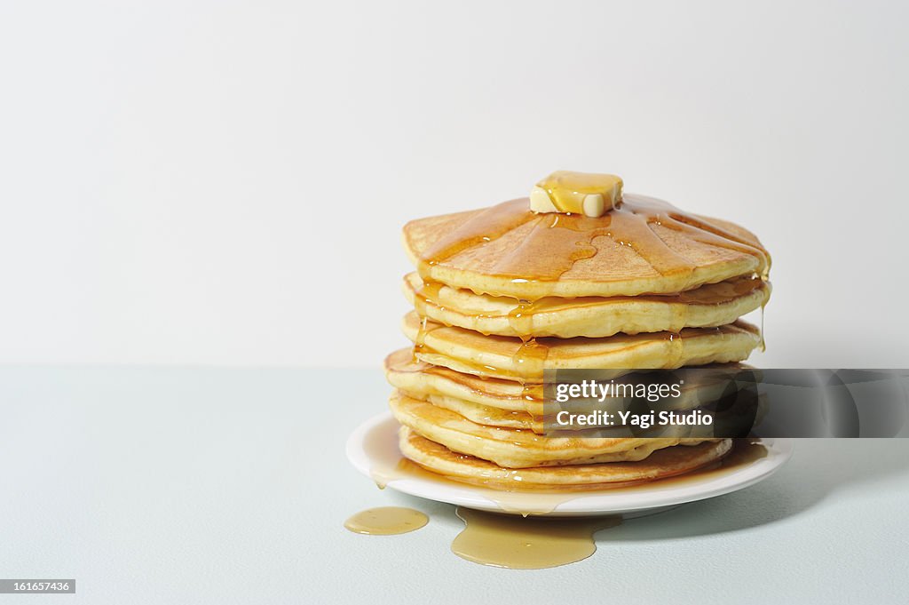 Honey dripping syrup on pancakes