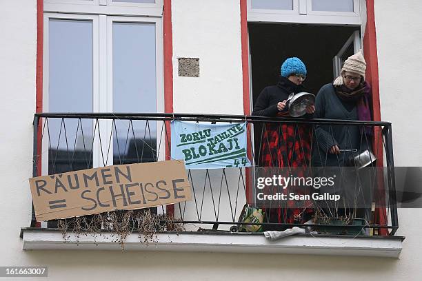 Two young women stand on a balcony next to a banner that reads: "Eviction = Shit" at Lausitzer Strasse 8 in protest against the eviction of the...