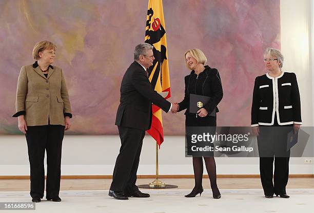 German President Joachim Gauck congratulates incoming German Education Minister Johanna Wanka after handing her her appointment papers as outgoing...