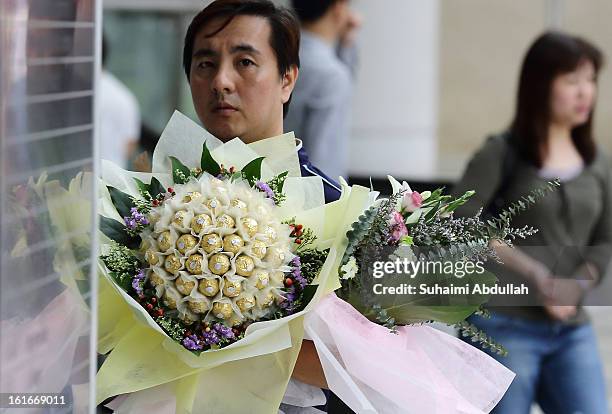 Man finds his way to deliver a Ferrero Rocher chocolate flower bouquet during Valentine's Day at Raffles Place on 14 February, 2013 in Singapore....