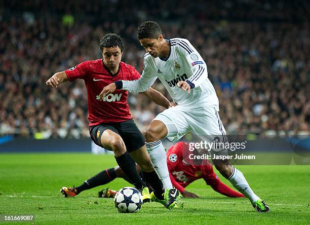 Raphael Varane of Real Madrid duels for the ball with Rafael of Manchester United during the UEFA Champions League Round of 16 first leg match...