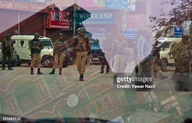 Indian policemen and paramilitary forces stand guard in the city centre during a relaxation in curfew, imposed after the execution of alleged Indian...