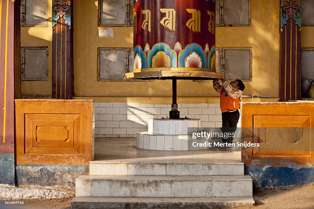 Young boy plays with prayer wheel