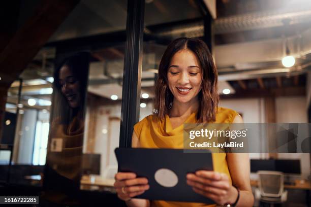 geschäftsfrau lächelt digitales tablet im modernen büro - tablet benutzen stock-fotos und bilder