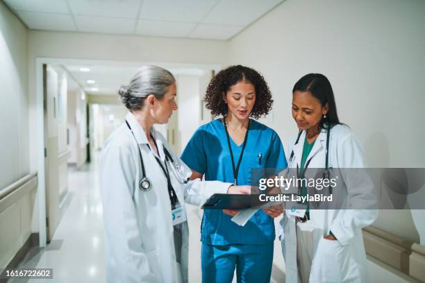 specialisti e infermiere che discutono del lavoro nel corridoio dell'ospedale - dottoressa foto e immagini stock