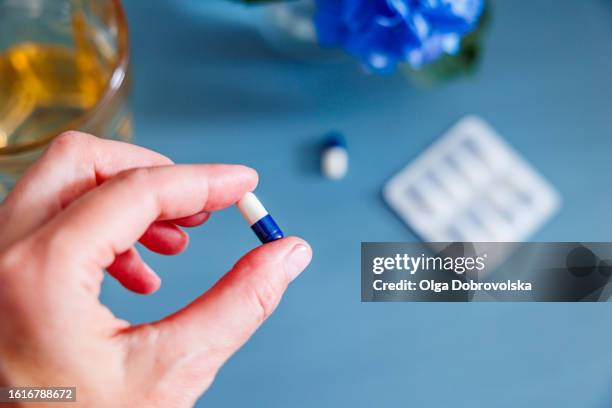 top view of a woman's hand holding a pill - servant stock pictures, royalty-free photos & images