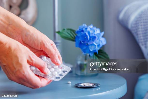 close-up of hands squeezing pills out of a blister pack - servant stock pictures, royalty-free photos & images