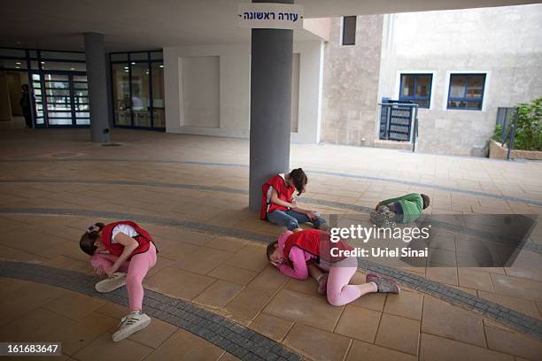 Israeli schoolchildren act as the wounded during a Home Front command drill simulating a rocket hitting a school on February 14, 2013 in Ra'anana,...